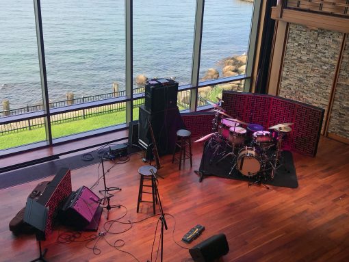 Impression Pro Series Bass Traps standing behind drumset and amplifier with view of water